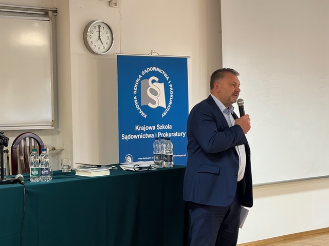 Minister Sprawiedliwości sędzia Waldemar Żurek  z mikrofonem trzymanym w dłoni, przemawiający do uczestników